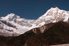Manaslu 07 10 Ngadu Chuli and Manaslu From Pung-gyen Gompa The Pung-gyen gompa (3870m) is named after Manaslu, as Pung-gyen means bracelet, a good description of the two peaks. To the left is Ngadi Chuli (Peak 29) and to the right the main summit of Manaslu and the East Pinnacle. The Pung-gyen Gompa was destroyed by fire during the winter of 1953 after the first Japanese expedition to Manaslu, killing 18 inhabitants, mostly nuns. The villagers believed the god residing on Manaslu destroyed the gompa to show his wrath for the trespassers, and refused to let the second Japanese expedition to Manaslu climb the mountain in 1954. When I got there, there was nobody home. I wonder where all the monks are gone?